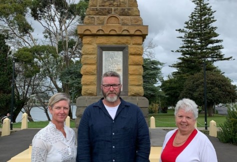 Three people pictured standing in a row in front of the Devonport Cenotaph in preparation for this year's Anzac Day services.