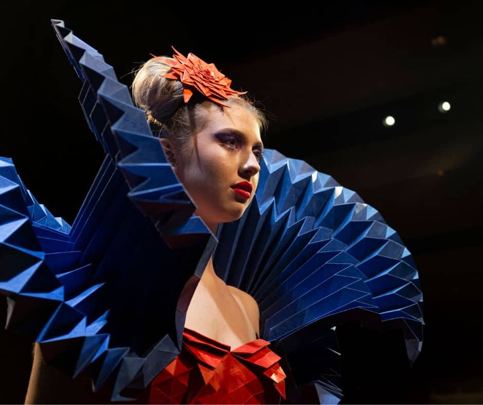 A woman in a red and blue paper dress as part of an international paper competition.