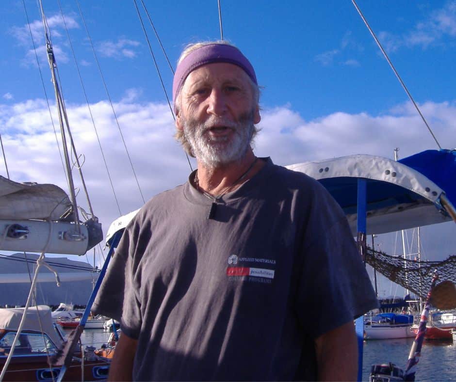 Peter Keating wearing a t-shirt standing in front of yachts and boats in a marina