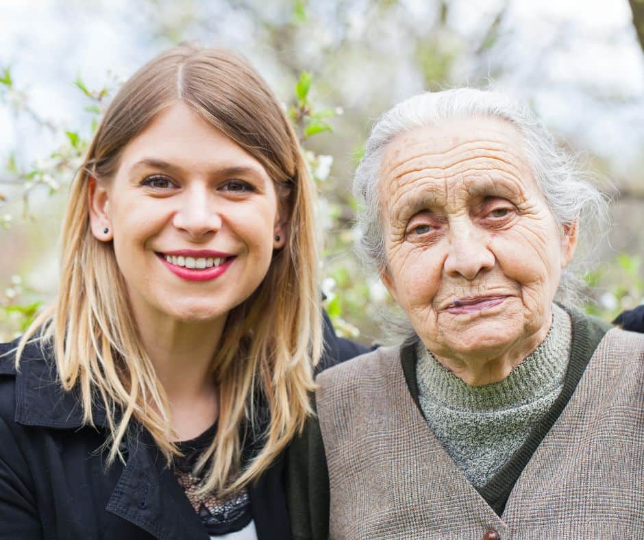 Image of Young woman smiling at the camera with an older woman