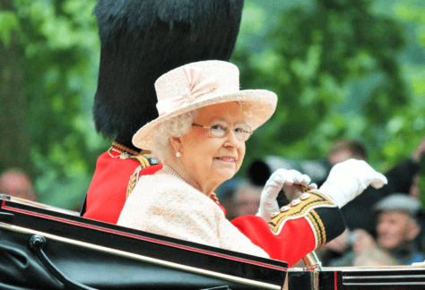 Her Majesty the Queen Elizabeth II sitting in a carriage looking towards the camera.