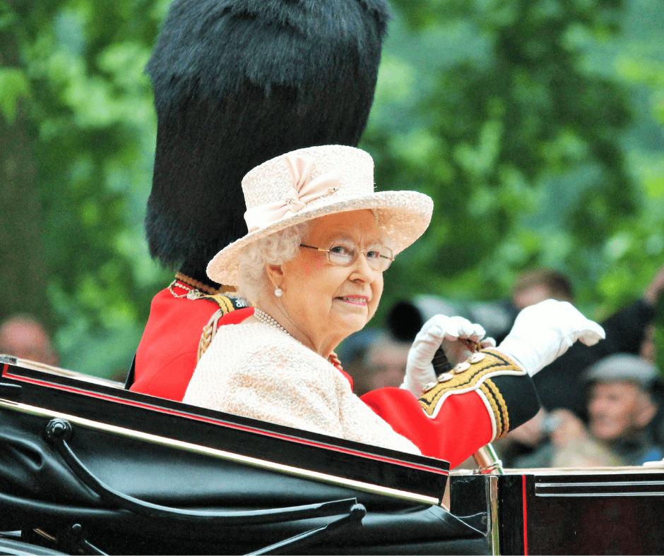 Her Majesty the Queen Elizabeth II sitting in a carriage looking towards the camera.