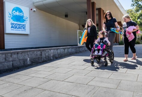 A family walking into Splash Aquatic and Leisure Centre, a child is in a wheel chair