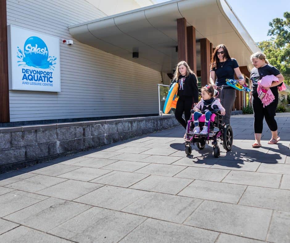 A family walking into Splash Aquatic and Leisure Centre, a child is in a wheel chair