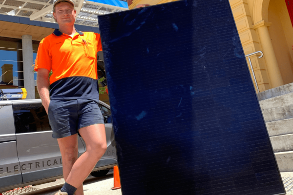 DES Electrical Contractors employee Joseph Robertson with one of the 148 solar panels that are currently being installed on the paranaple arts centre roof as part of Devonport City Council’s strategic goal to live lightly on the environment.